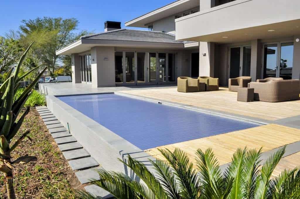 A swimming pool in front of a house.